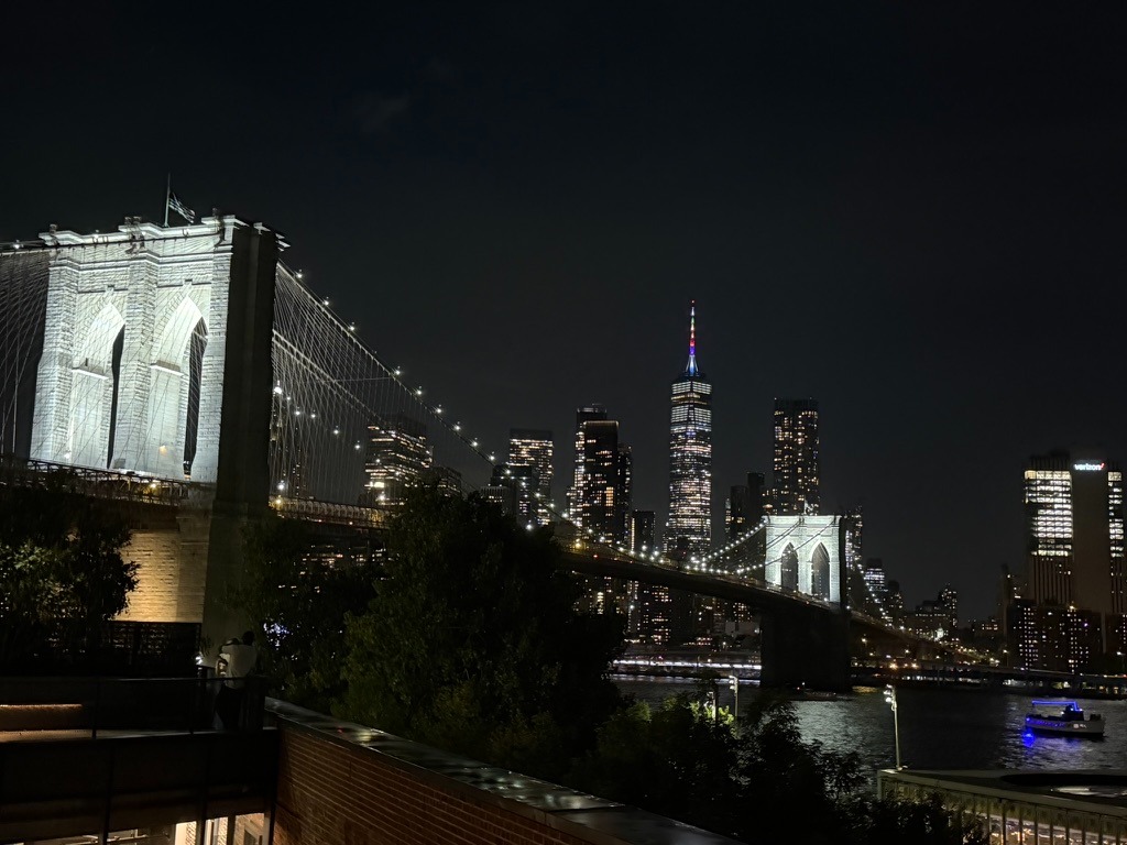 Nighttime view of the Brooklyn Bridge and New York skyline.